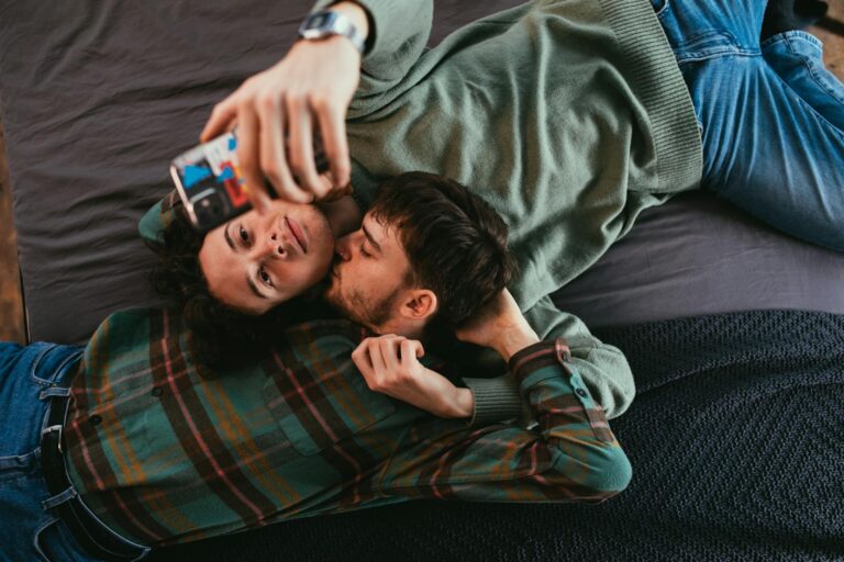 A close-up of a couple sharing an intimate moment while taking a selfie indoors.