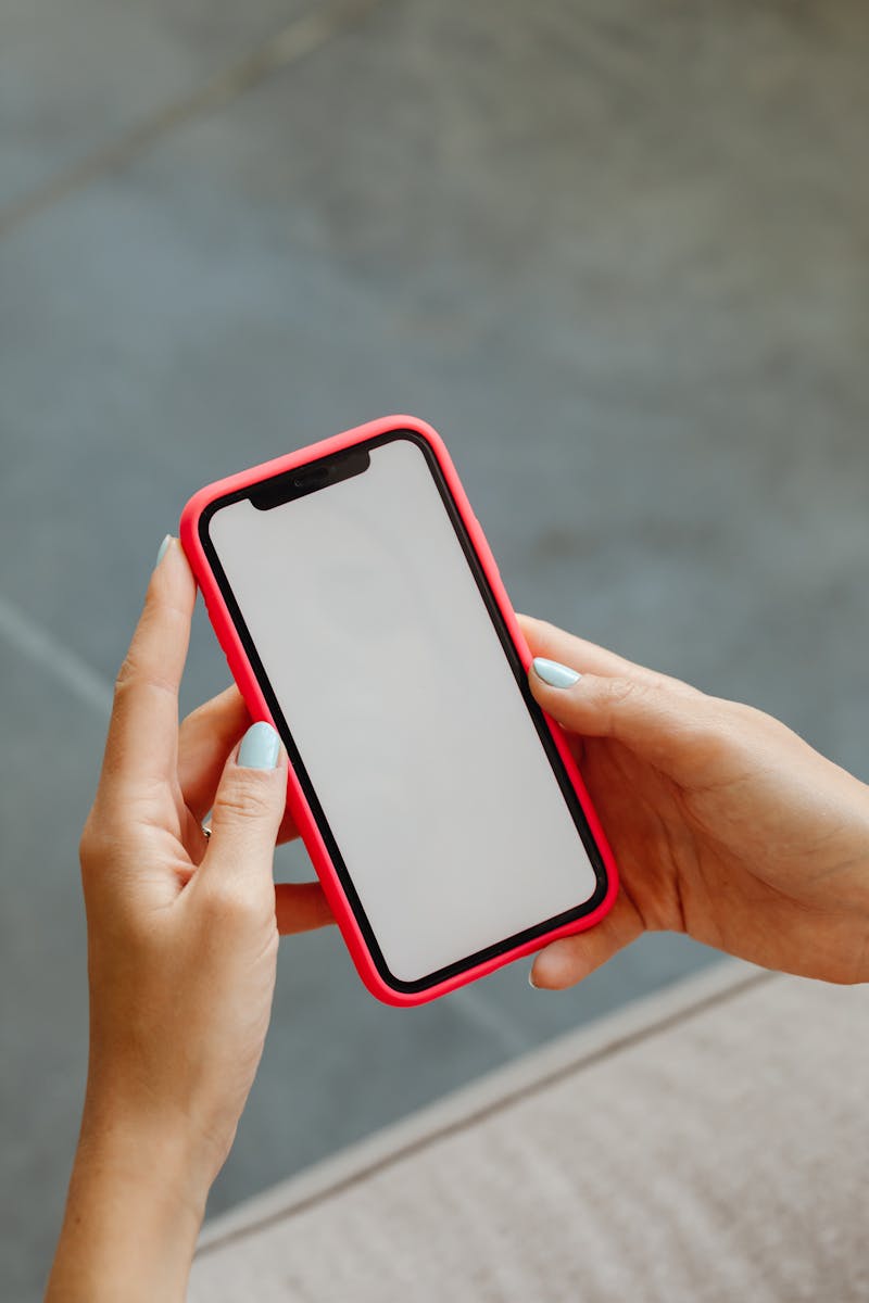 Close-up view of hands holding a smartphone with a blank screen.