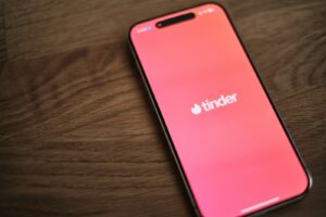 A pink iPhone sitting on top of a wooden table