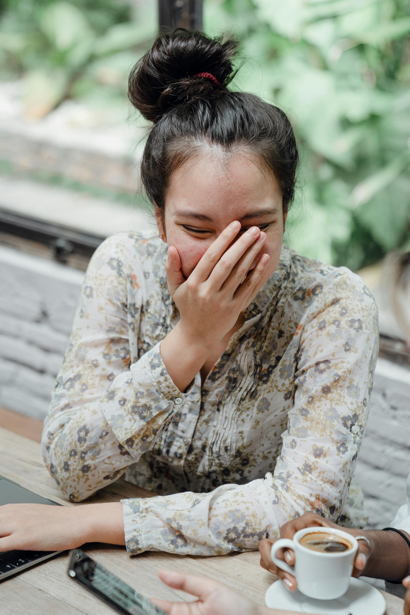 Woman enjoying a lighthearted moment with friends in a cozy café.